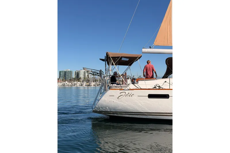 Slide: The Image of 2011 Jeanneau 53 sailboat on calm water, city skyline in background. - 96