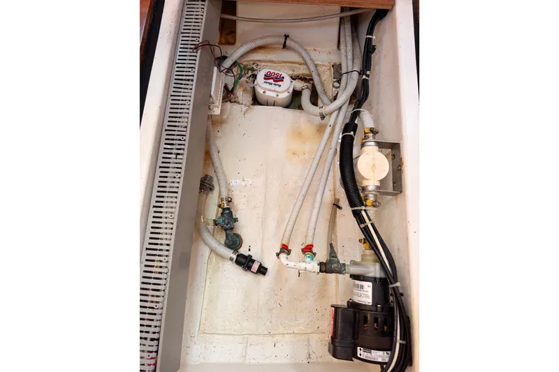 Slide: The Image of Bilge area of a 2007 Beneteau 49 sailboat, showing pumps and hoses. - 100