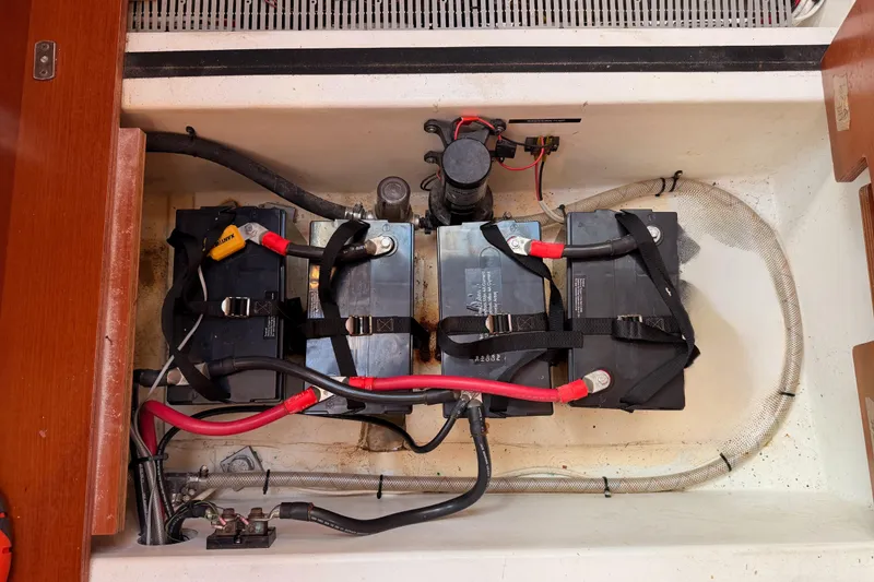 Slide: The Image of Battery compartment of a 2007 Beneteau 49 sailboat, featuring three secured batteries. - 101