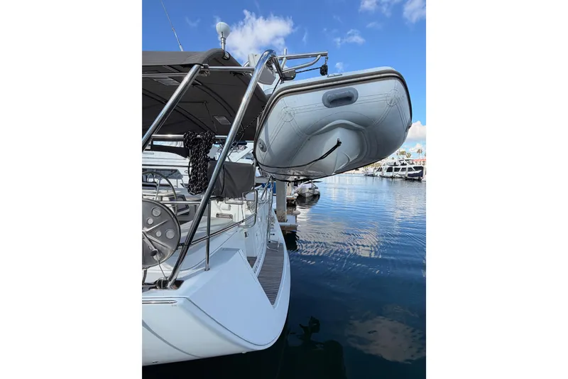 Slide: The Image of 2007 Beneteau 49 yacht with dinghy, docked in a marina under clear blue skies. - 11