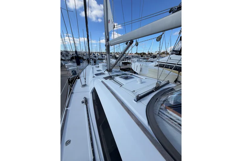 Slide: The Image of 2007 Beneteau 49 sailboat deck view, docked in a marina under blue skies. - 16