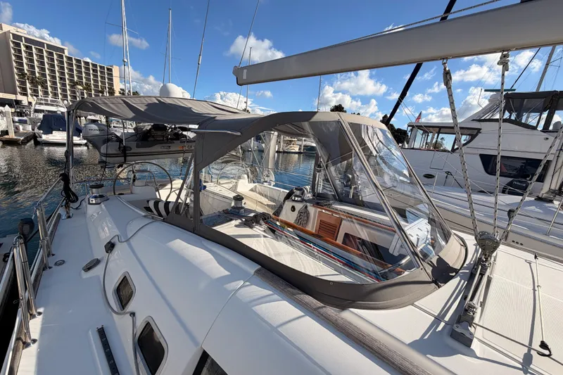 Slide: The Image of 2007 Beneteau 49 sailboat docked at marina, featuring spacious cockpit and protective canopy. - 26