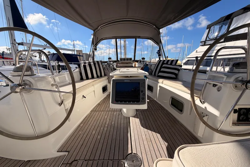 Slide: The Image of Cockpit of 2007 Beneteau 49 sailboat with dual steering wheels and striped cushions. - 32