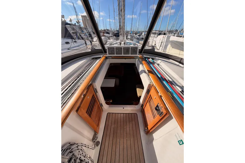 Slide: The Image of Interior view of 2007 Beneteau 49 sailboat cockpit with wooden accents and marina backdrop. - 44