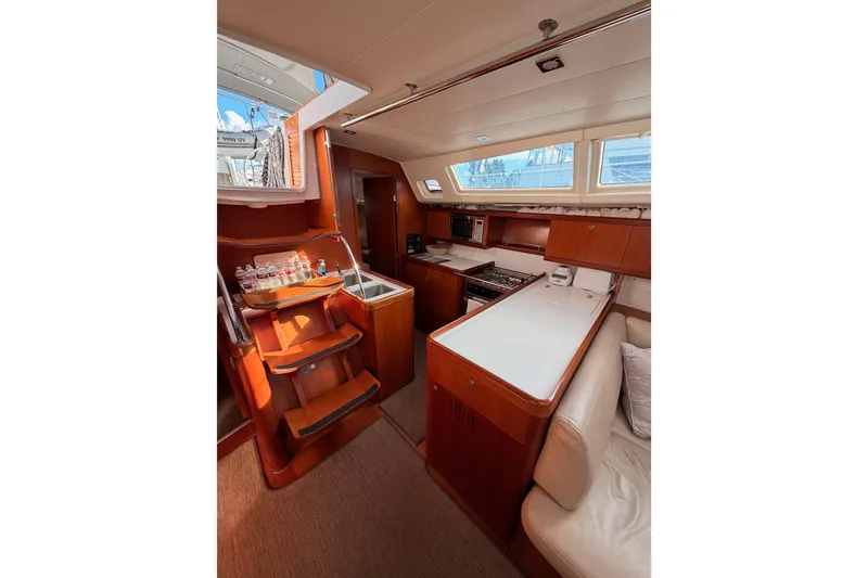 Slide: The Image of Interior of 2007 Beneteau 49 yacht, featuring a modern kitchen and seating area. - 48