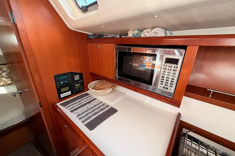Slide: The Image of Interior of 2007 Beneteau 49 yacht with microwave and wooden cabinetry. - 55