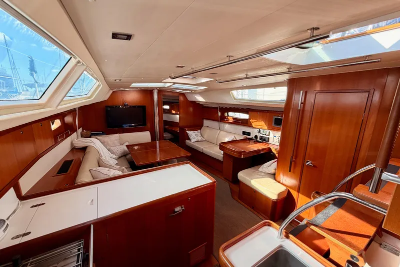 Slide: The Image of Luxurious interior of a 2007 Beneteau 49 yacht with elegant wood finishes and spacious seating. - 62