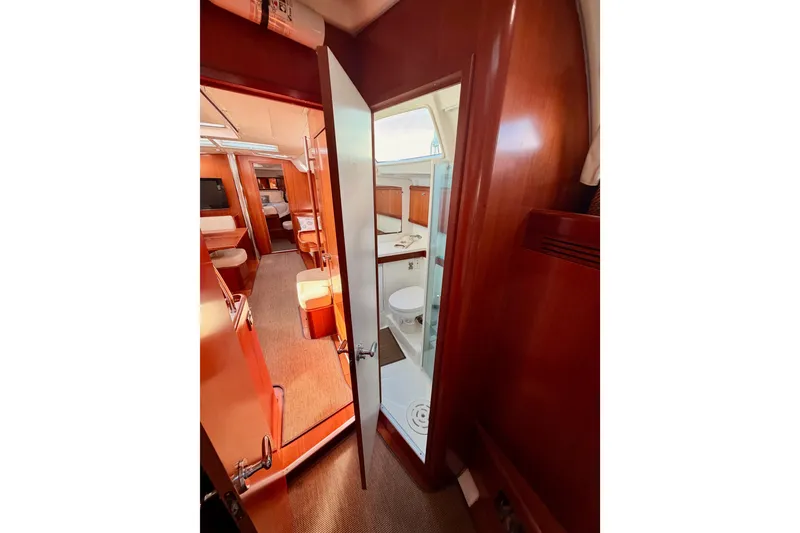 Slide: The Image of Interior of 2007 Beneteau 49 yacht, featuring wood finishes and a compact bathroom. - 70
