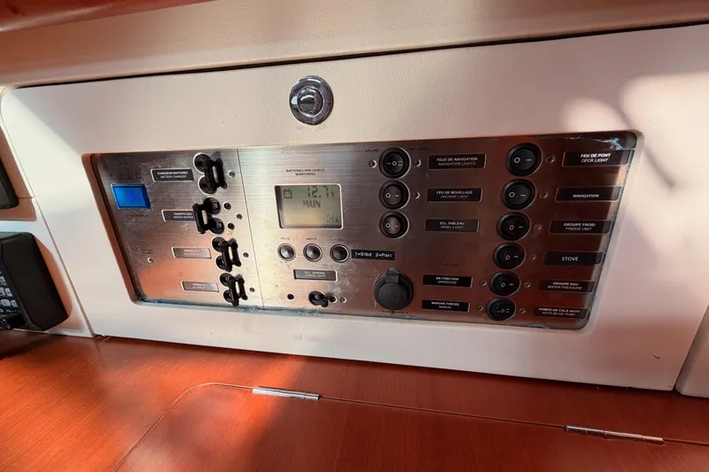 Slide: The Image of Control panel of a 2007 Beneteau 49 yacht, featuring various switches and displays. - 76