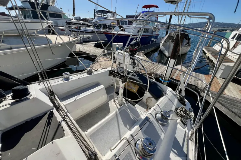 Slide: The Image of 1986 Hunter Legend 45 sailboat cockpit at marina, surrounded by other boats. - 15