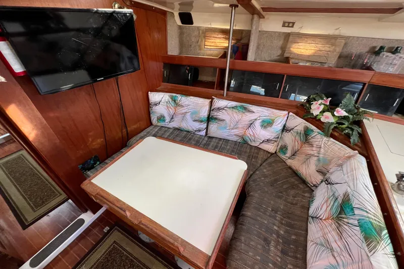 Slide: The Image of Interior of 1986 Hunter Legend 45 sailboat with cozy dining area and floral cushions. - 20