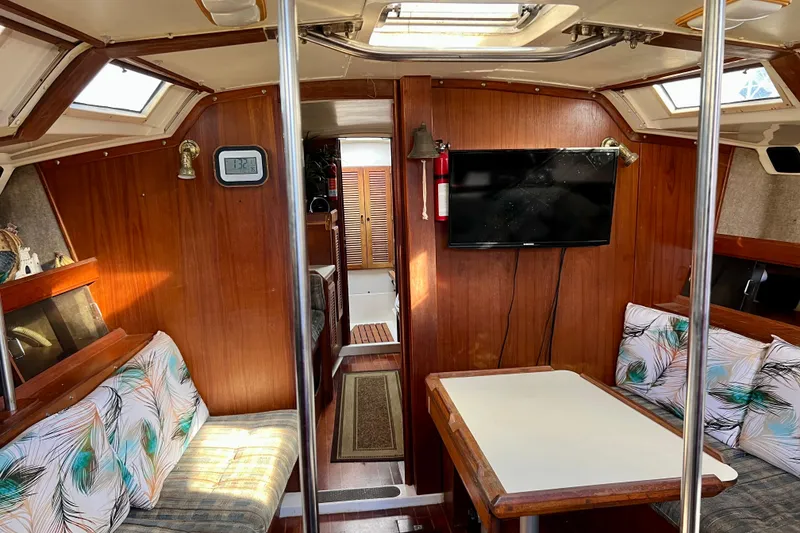 Slide: The Image of Interior of 1986 Hunter Legend 45 sailboat with wood paneling and cozy seating area. - 21