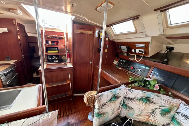 Slide: The Image of 1986 Hunter Legend 45 yacht interior with wood finish, navigation panel, and cozy seating area. - 24
