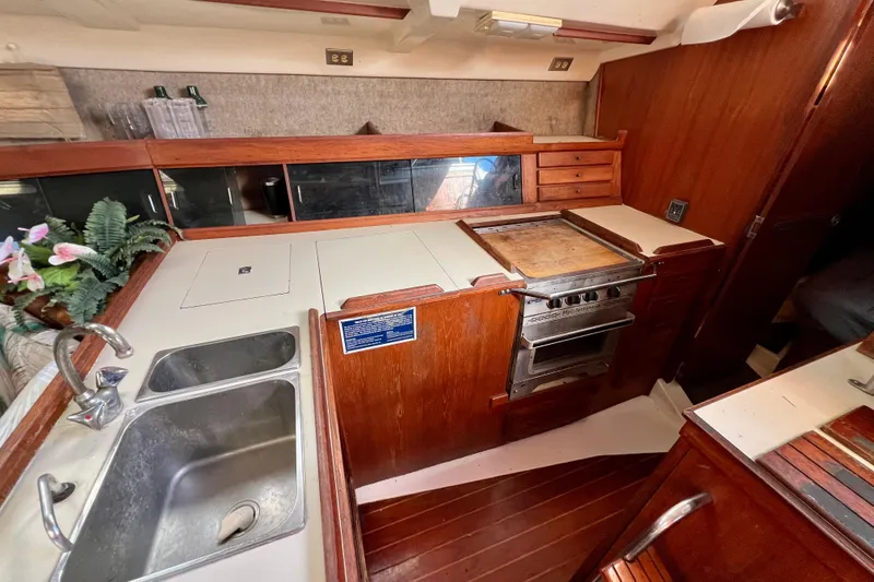 Slide: The Image of 1986 Hunter Legend 45 yacht kitchen with wooden cabinetry and dual sink. - 28