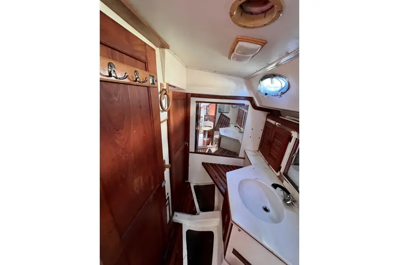 Slide: The Image of Interior of 1986 Hunter Legend 45 sailboat, featuring wooden cabinetry and compact bathroom. - 30