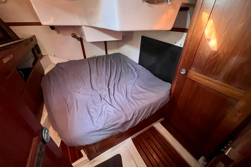 Slide: The Image of Cozy cabin interior of 1986 Hunter Legend 45 sailboat with wooden accents and bed. - 31