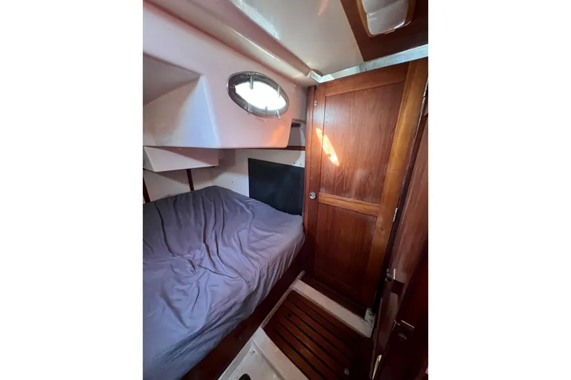 Slide: The Image of Cozy cabin interior of 1986 Hunter Legend 45 sailboat with wooden door and porthole. - 33