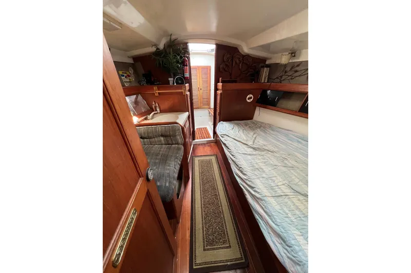 Slide: The Image of Interior of 1986 Hunter Legend 45 sailboat with cozy wooden furnishings and bedding. - 34