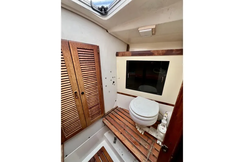 Slide: The Image of 1986 Hunter Legend 45 yacht bathroom with wooden accents and compact toilet. - 36
