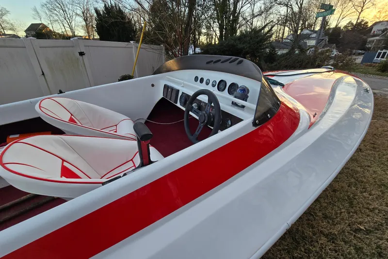 Slide: The Image of 1978 Allison Boats 20 with red and white interior, sleek design, and classic dashboard. - 25