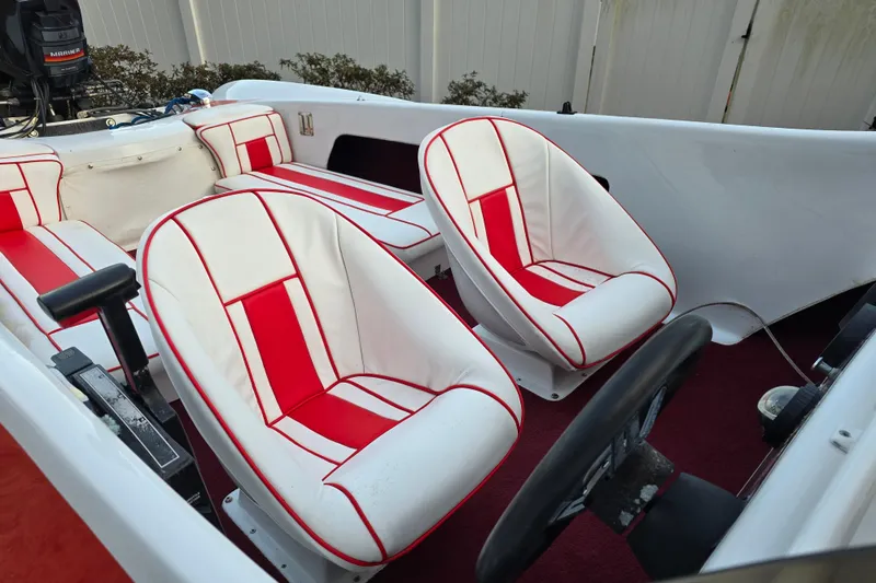 Slide: The Image of 1978 Allison Boats 20 interior with red and white seats, steering wheel, and Mariner engine. - 7
