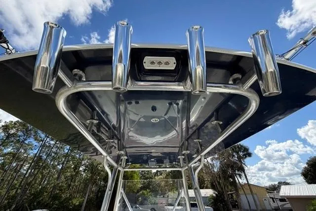 Slide: The Image of Stuart 27 boat T-top with rod holders, 2017 model, under a clear blue sky. - 2
