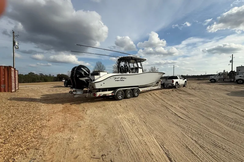 Slide: The Image of 2023 Cape Horn 34 XS boat on trailer, parked in a sandy area under cloudy sky. - 19