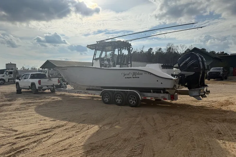 Slide: The Image of 2023 Cape Horn 34 XS boat on trailer, attached to a white truck, under cloudy sky. - 25
