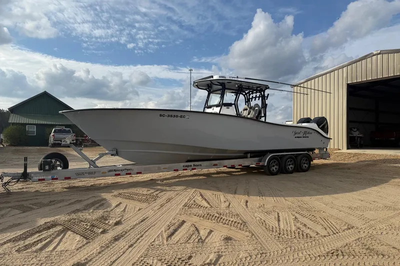 Slide: The Image of 2023 Cape Horn 34 XS boat on trailer, parked near a large shed. - 29