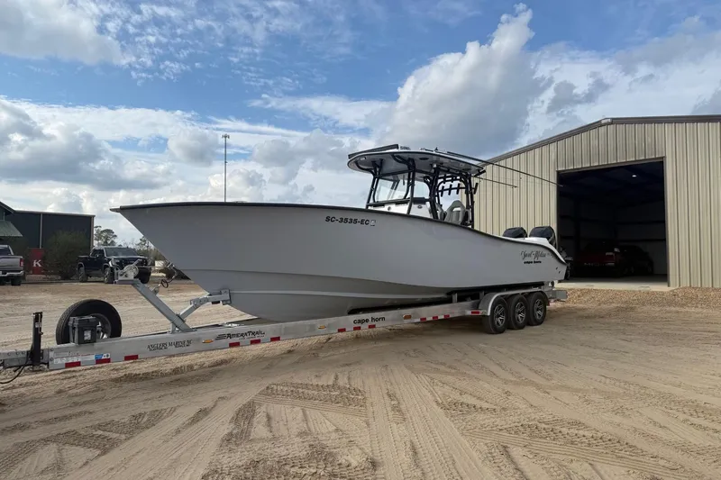 Slide: The Image of 2023 Cape Horn 34 XS boat on trailer outside a large metal building. - 35