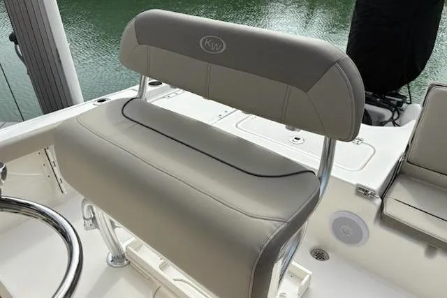 Slide: The Image of 2023 Key West 210 Bay Reef boat seat, gray upholstery, sleek design, on calm water. - 15