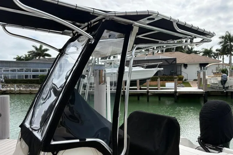 Slide: The Image of 2023 Key West 210 Bay Reef boat with T-top, docked by waterfront homes. - 18