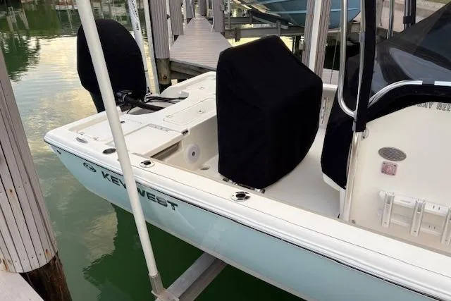 Slide: The Image of 2023 Key West 210 Bay Reef boat docked, featuring covered seats and sleek design. - 25