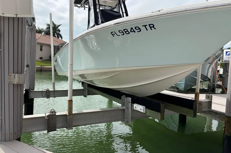 Slide: The Image of 2023 Key West 210 Bay Reef boat docked on a lift in a marina. - 3