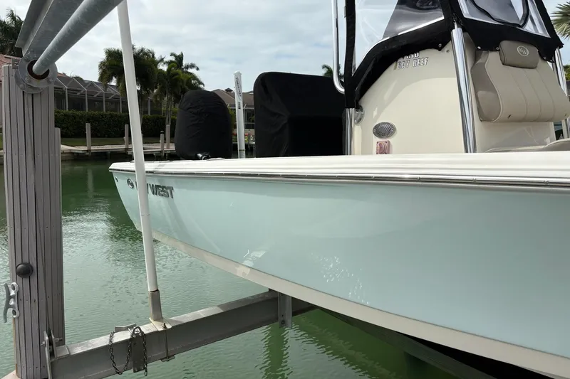 Slide: The Image of 2023 Key West 210 Bay Reef boat docked on a lift in a marina setting. - 5