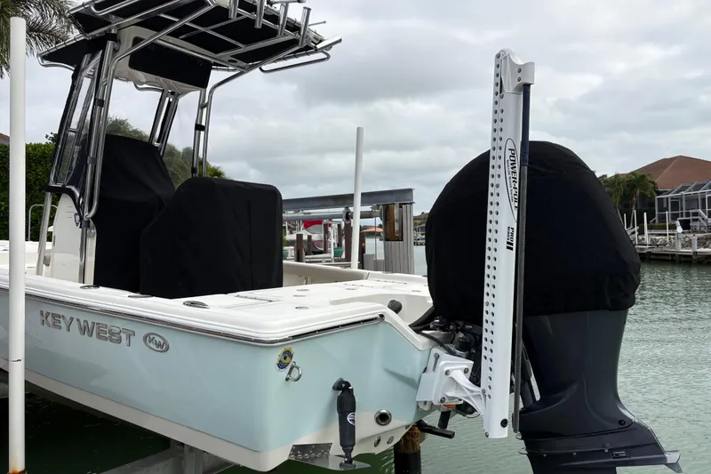 Slide: The Image of 2023 Key West 210 Bay Reef boat docked, featuring covered seats and motor, with a Power-Pole anchor. - 7