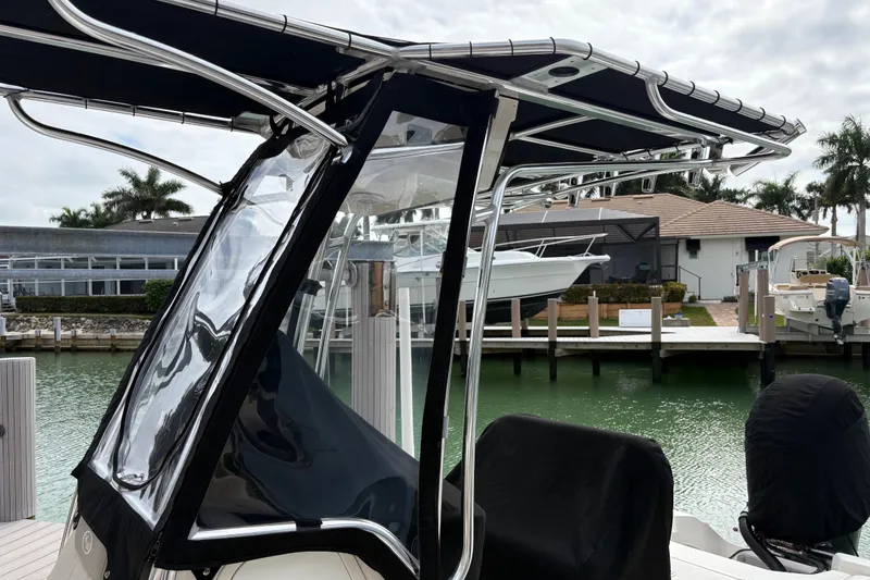 Slide: The Image of 2023 Key West 210 Bay Reef boat docked with T-top and clear enclosure. - 9