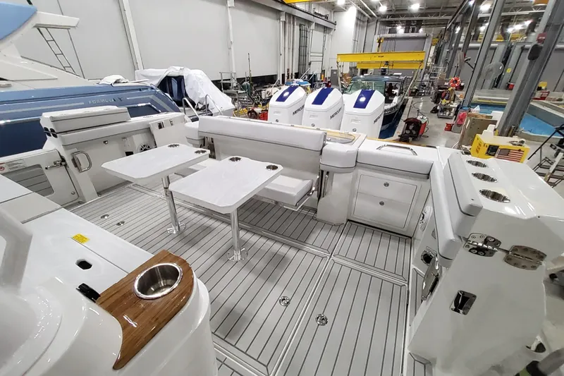 Slide: The Image of 2026 Formula 457 Center Console Fish boat interior with seating and tables in a workshop. - 40