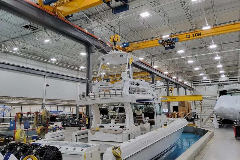 Slide: The Image of 2026 Formula 457 Center Console Fish boat in a manufacturing facility with overhead cranes. - 6