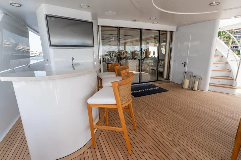 Slide: The Image of Luxurious 2006 Westport 130 Motoryacht deck with bar, seating, and elegant wood flooring. - 17