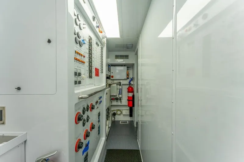 Slide: The Image of Engine room of 2006 Westport 130 Motoryacht with control panels and fire extinguisher. - 48