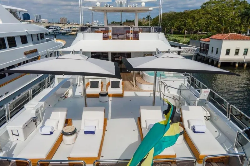 Slide: The Image of Luxurious 2006 Westport 130 Motoryacht deck with sun loungers and umbrellas, docked at marina. - 7