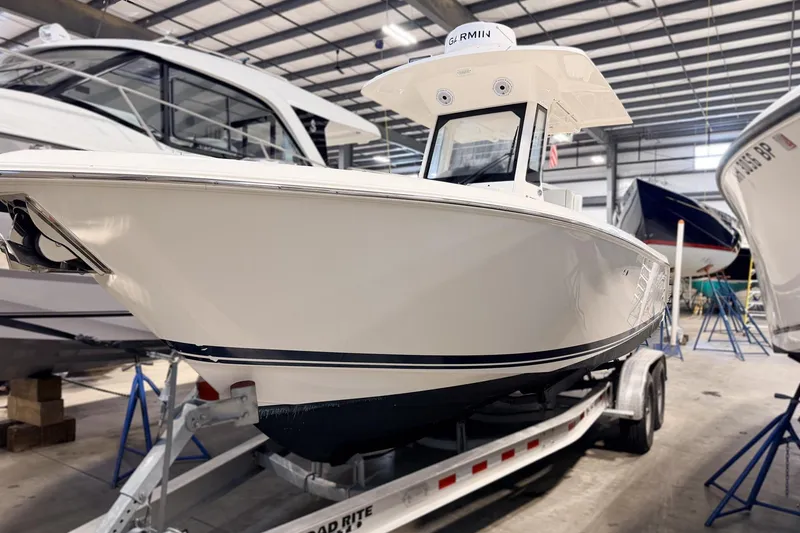 The Image of 2023 Pursuit S 268 Sport boat on trailer in indoor showroom. - 0