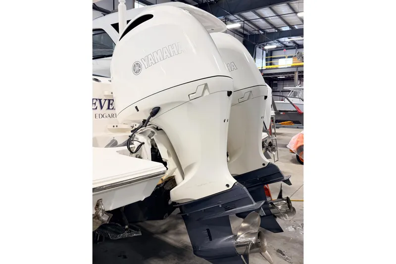 Slide: The Image of 2023 Pursuit S 268 Sport boat with dual Yamaha outboard engines in a warehouse. - 10