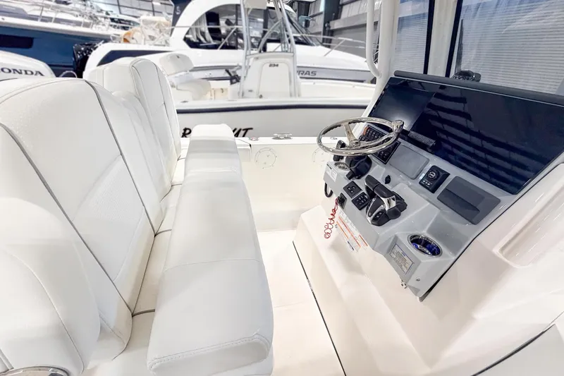 Slide: The Image of 2023 Pursuit S 268 Sport boat interior with sleek white seating and modern control panel. - 3