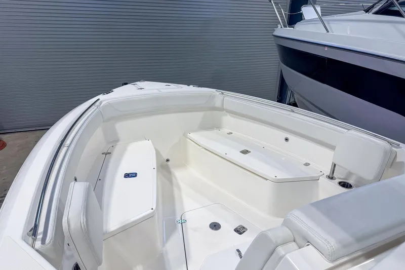 Slide: The Image of 2023 Pursuit S 268 Sport boat interior with white seating and storage compartments. - 6