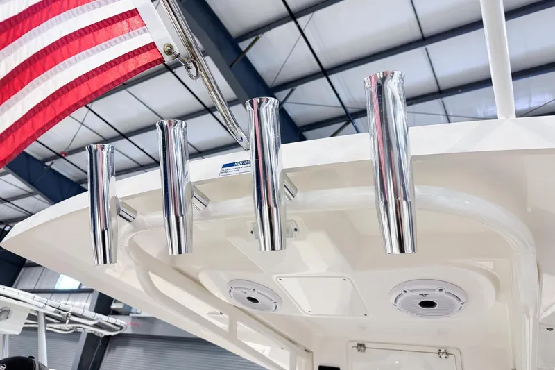 Slide: The Image of 2023 Pursuit S 268 Sport boat with rod holders and American flag in a showroom. - 9