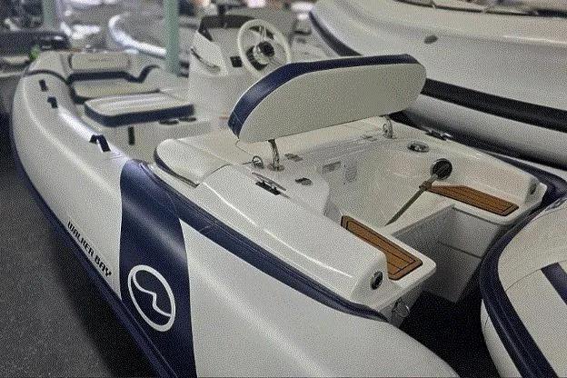 Slide: The Image of 2025 Walker Bay Generation 12 LTE boat interior with seating and steering console. - 6