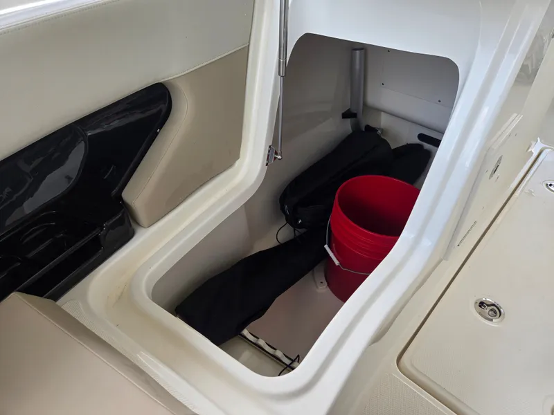 Slide: The Image of Storage compartment in 2026 Boston Whaler 240 Vantage with red bucket. - 18