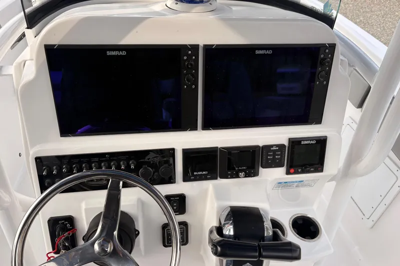 Slide: The Image of 2022 Aquasport 2500 Center Console dashboard with dual Simrad displays and controls. - 15
